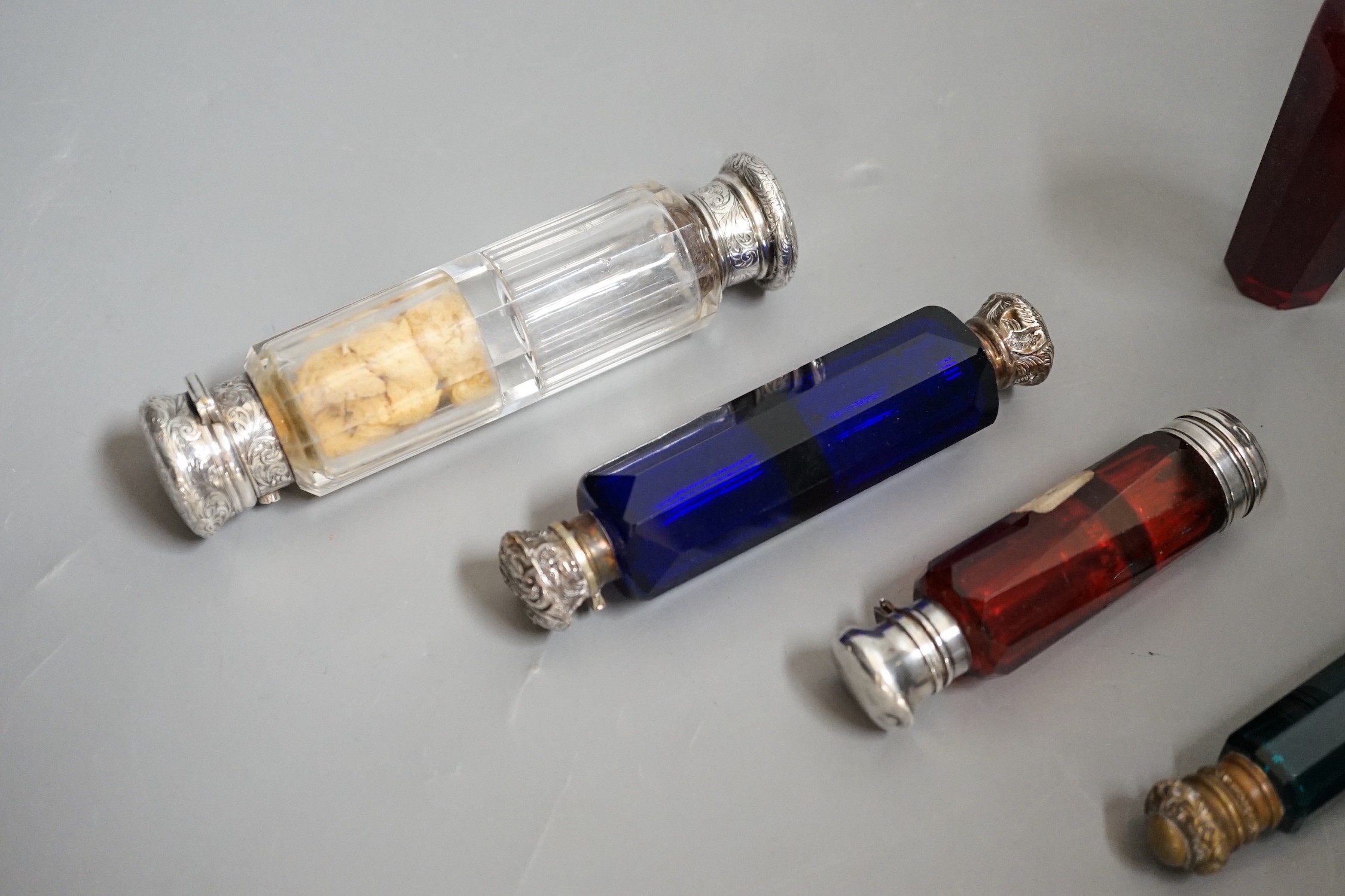 A collection of 19th century coloured and clear glass scent bottles, some silver mounted (6)